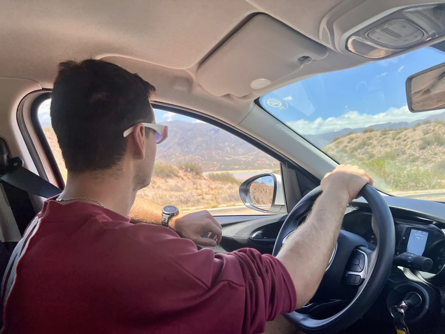 Driving the rental car along the road out of El Calafate, dry scrub and hills ahead