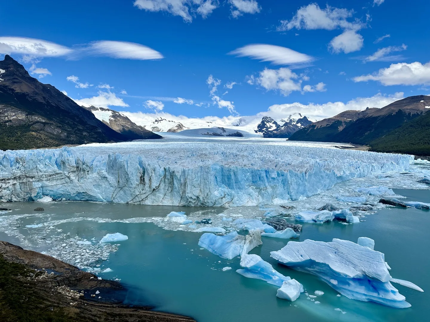 Chunks of ice floating in the milky water below the front of Perito Moreno Glacier