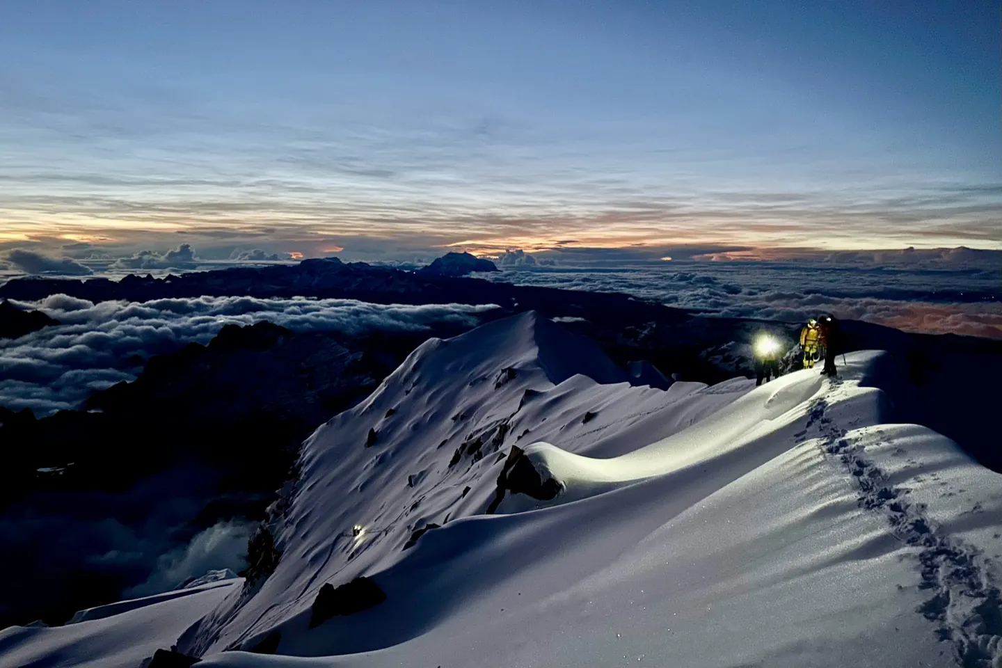 A climber&rsquo;s headtorch still lit as dawn breaks on the final push to the Huayna Potosi summit