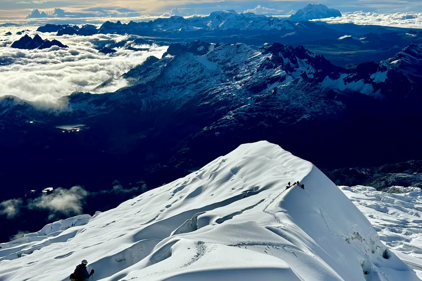 Climbers strung out along the narrow snow ridge on the final section to the Huayna Potosi summit