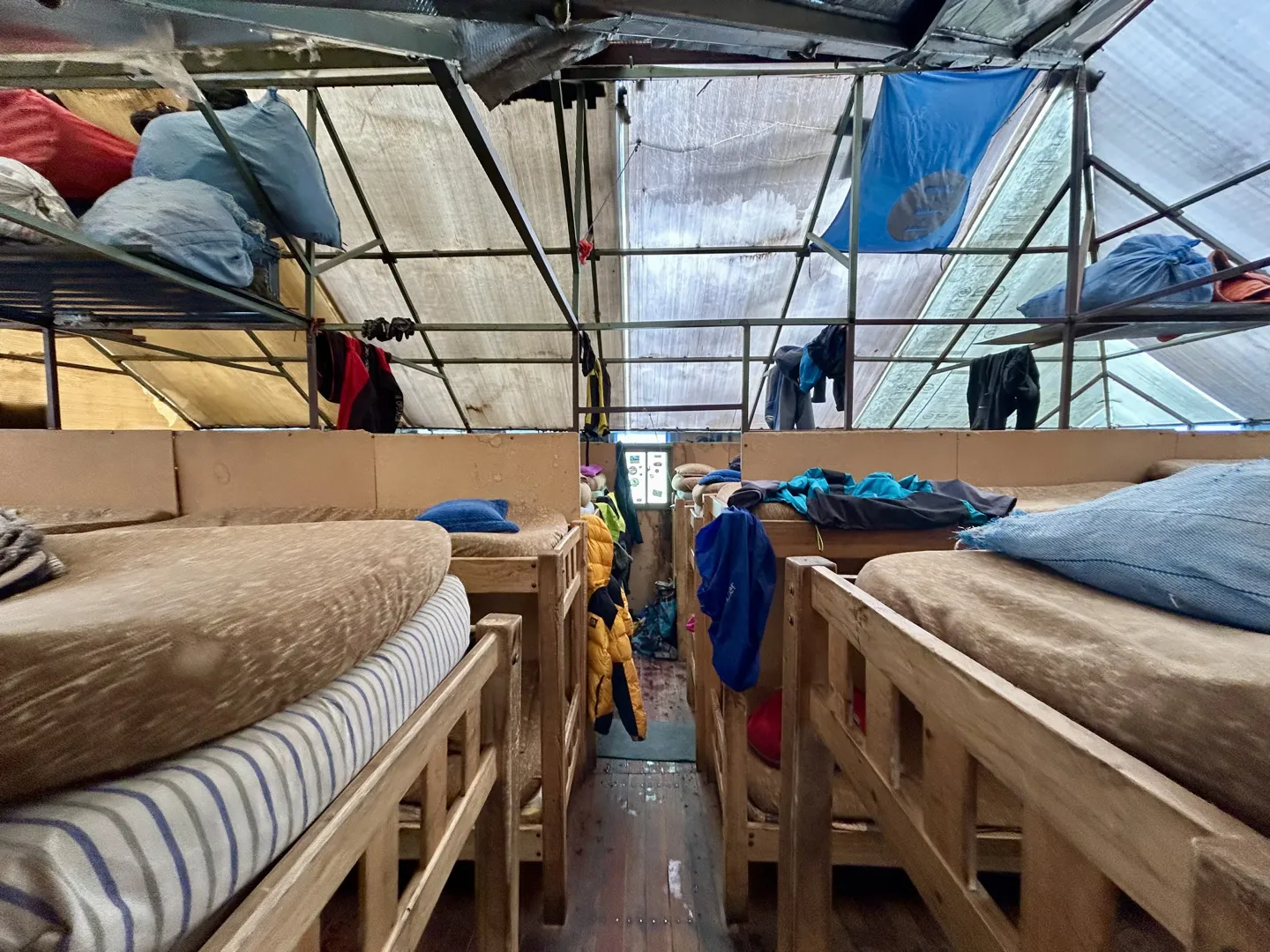 Tightly packed wooden bunks and gear drying inside the Huayna Potosi high camp refuge