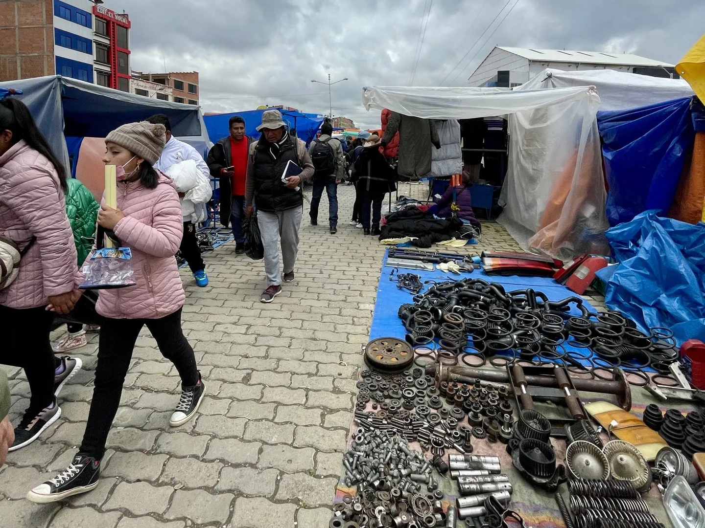 Tools and engine parts laid out on tarpaulins at a La Paz street market