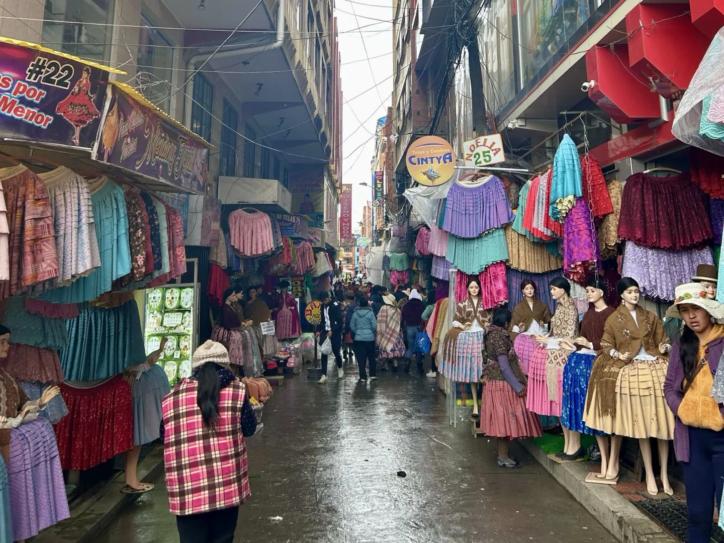 Pollera skirts and dresses hanging outside shops on a narrow La Paz street
