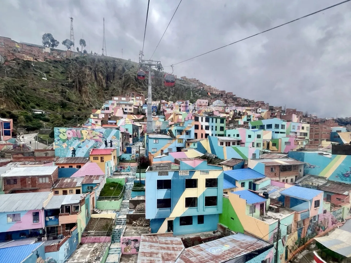 Brightly painted houses covering a La Paz hillside beneath the cable car line