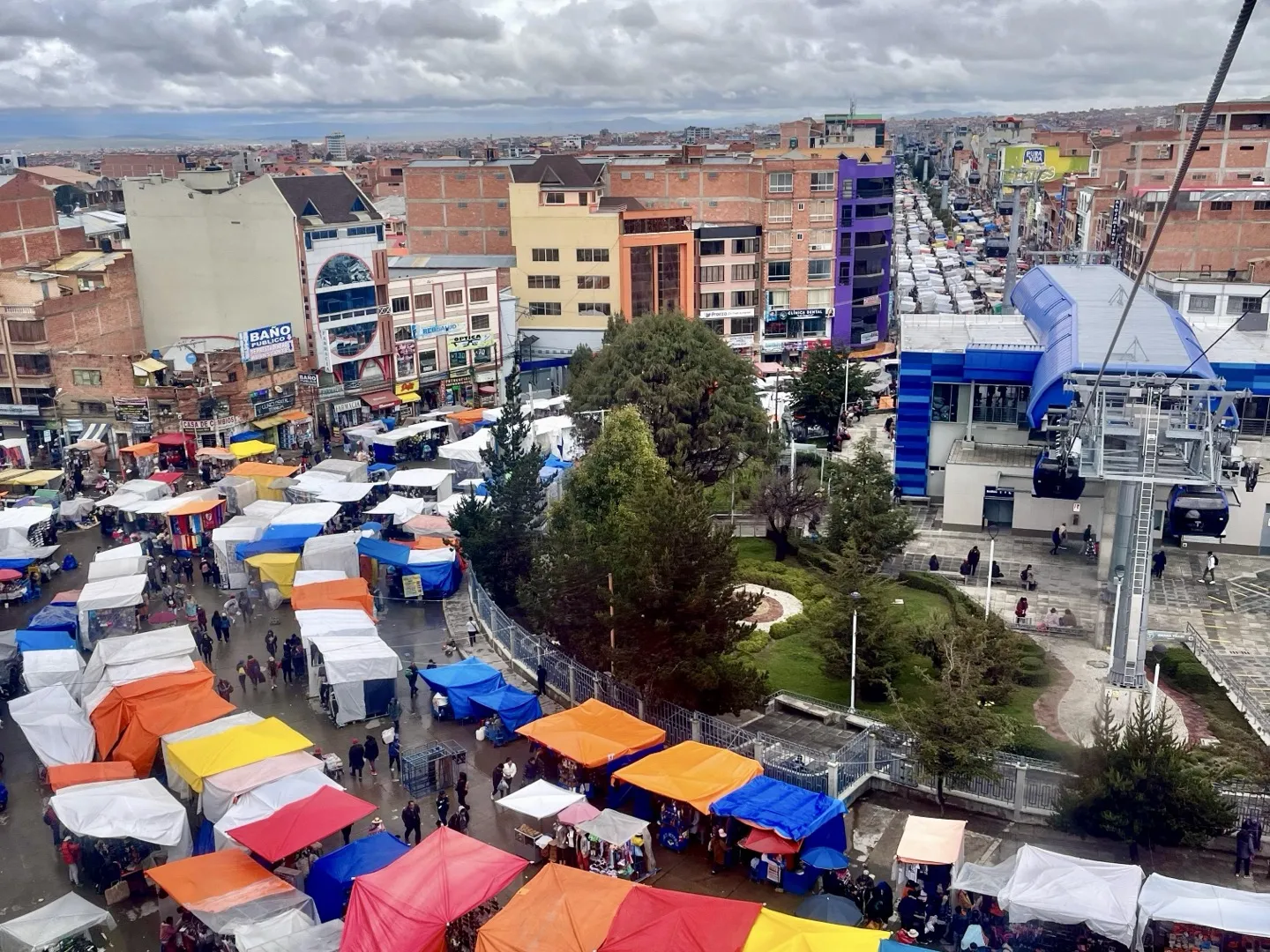Market stalls and a cable car station seen from above in La Paz