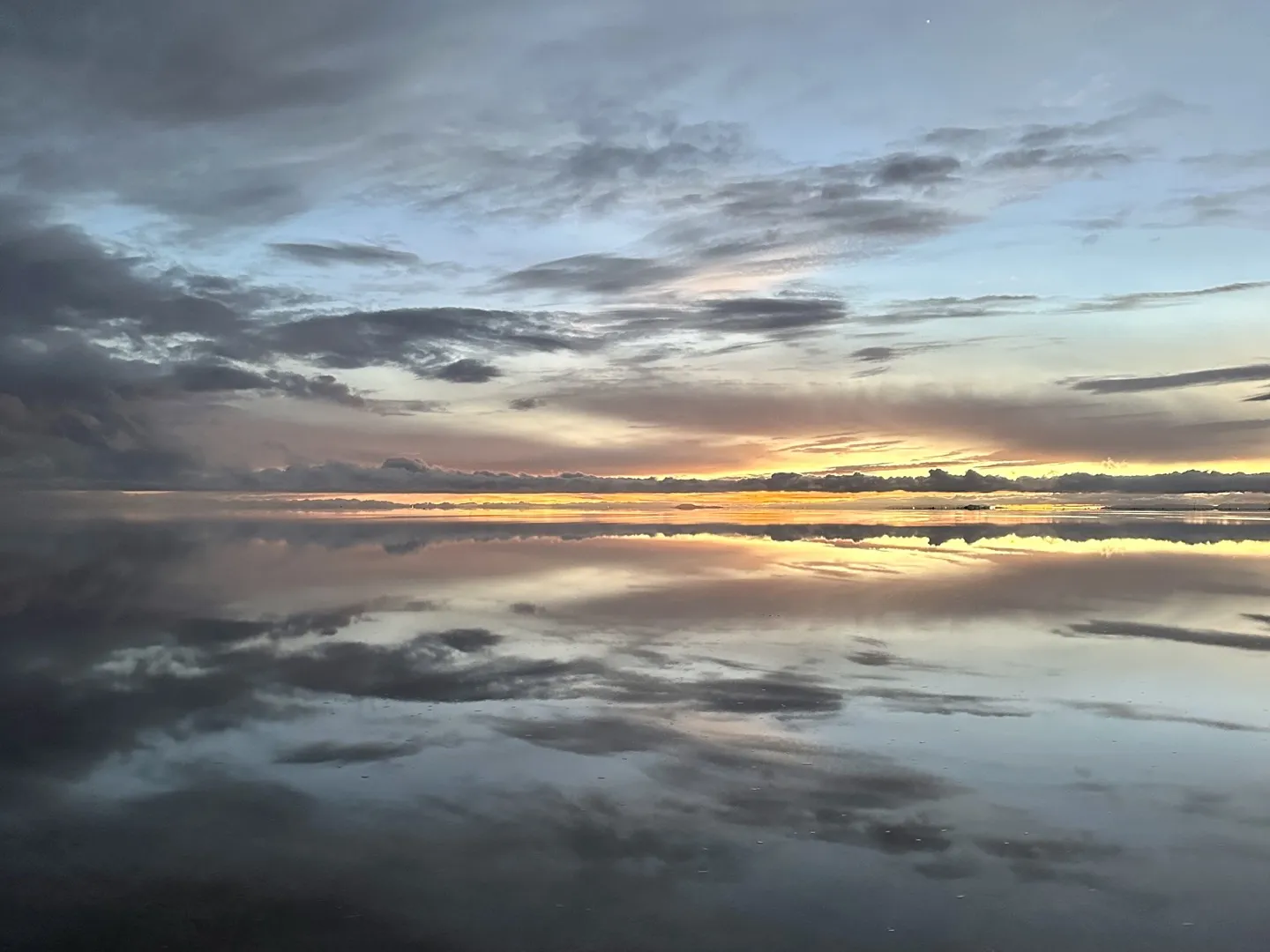 First light on the Salar de Uyuni, the clouds mirrored perfectly in the thin layer of water