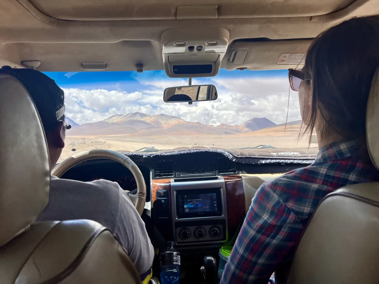 View through the 4WD windscreen driving across the Dali Desert towards distant mountains