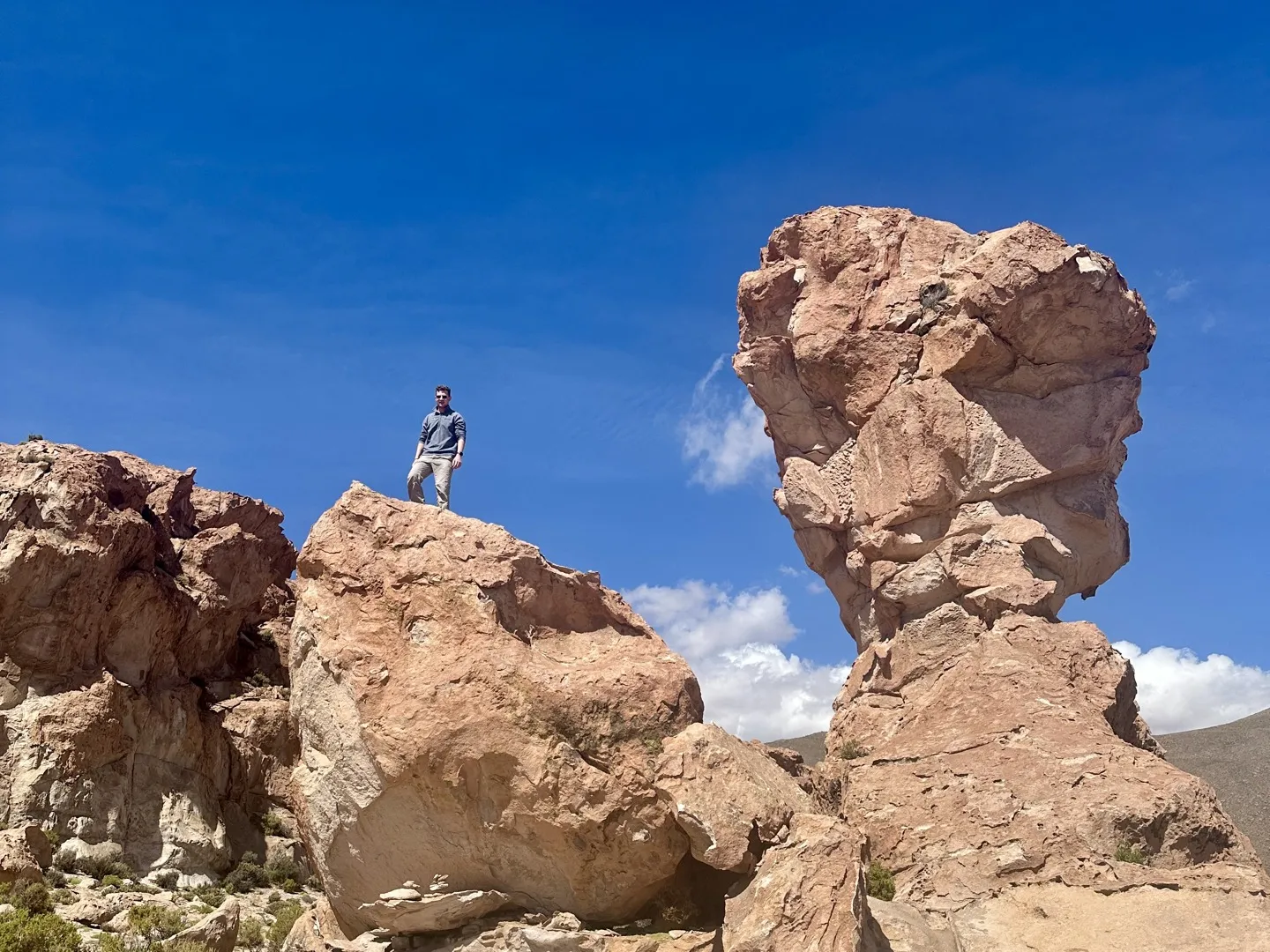 Standing on top of a boulder among the red rock formations near Copa del Mundo