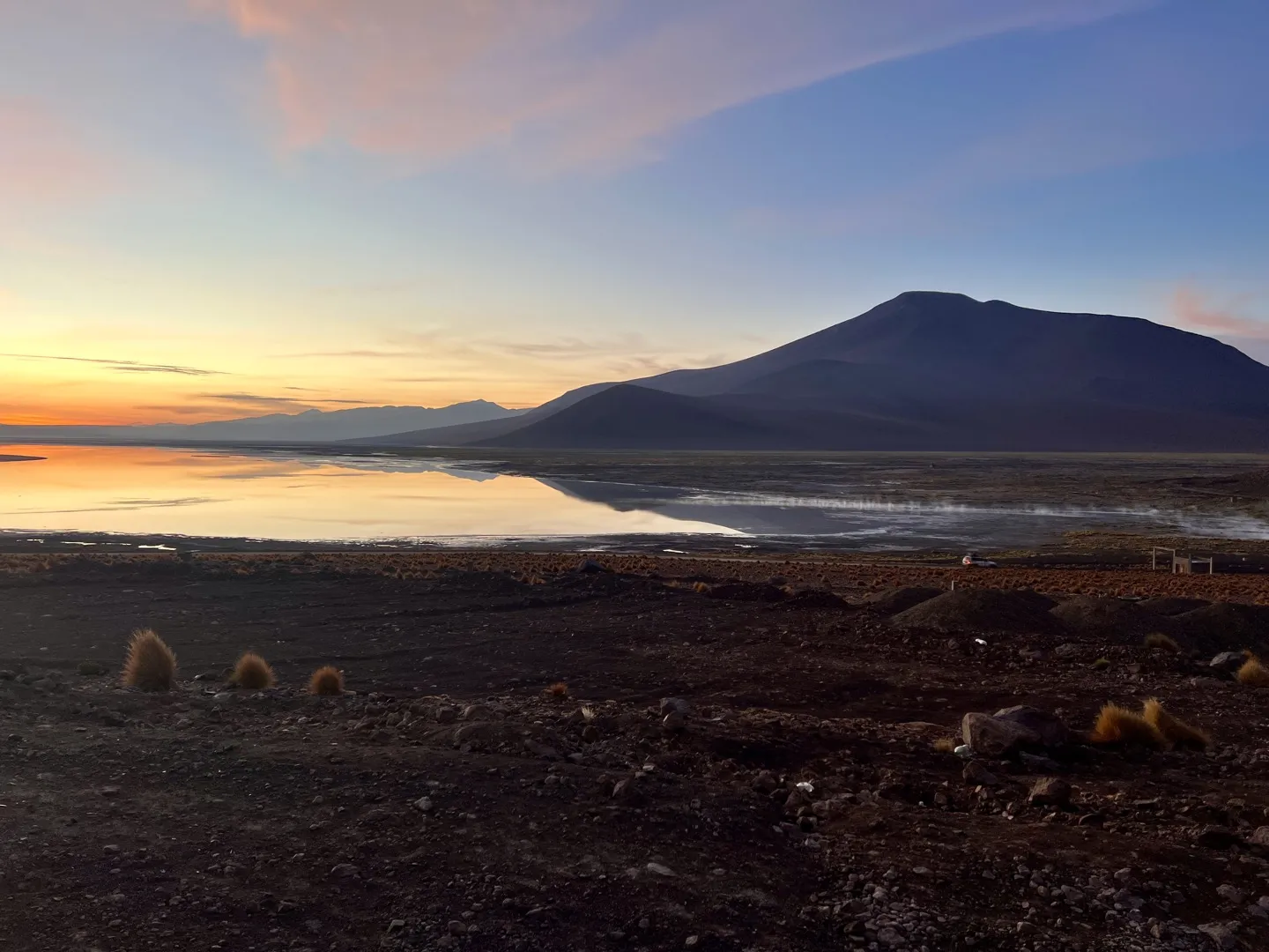 Sunrise turning the sky orange over a lagoon and volcano soon after leaving Chalviri on Day 3