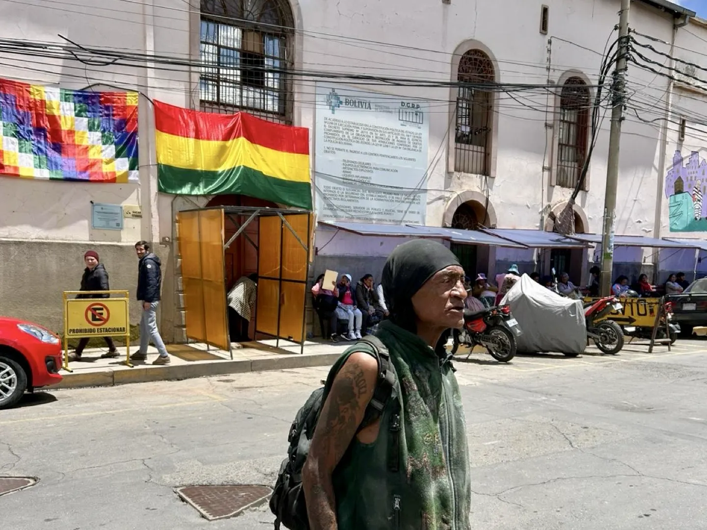 Crazy Dave in the street outside the flag-draped entrance to San Pedro Prison in La Paz