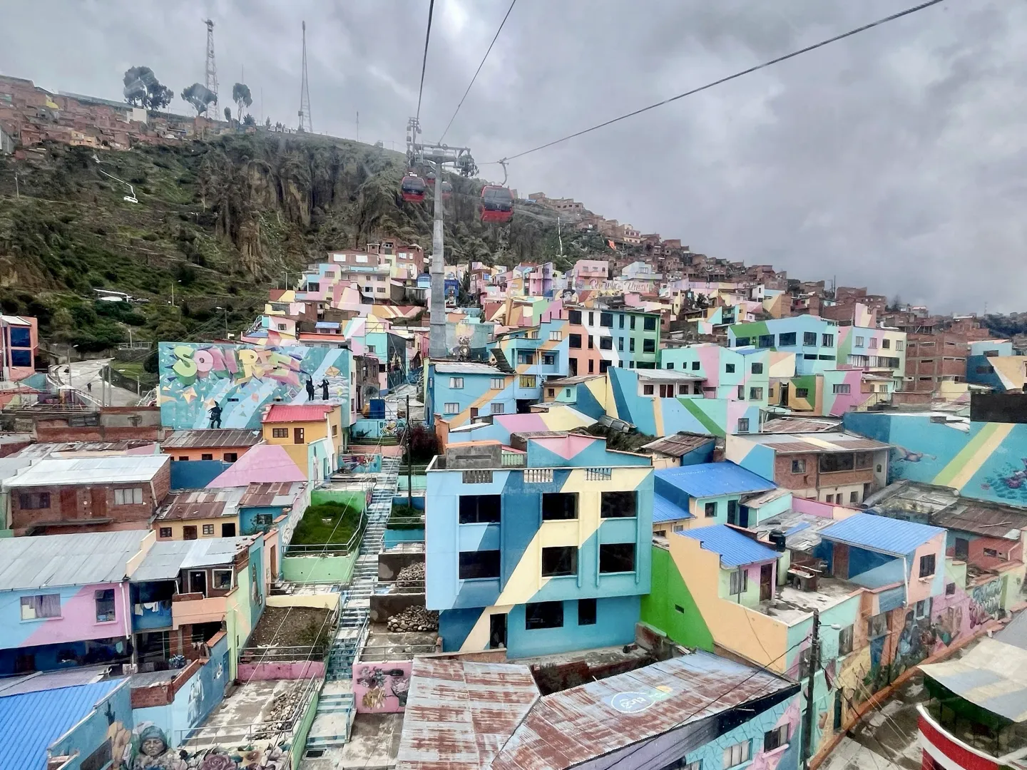 Brightly painted houses stacked up a La Paz hillside below the cable car line