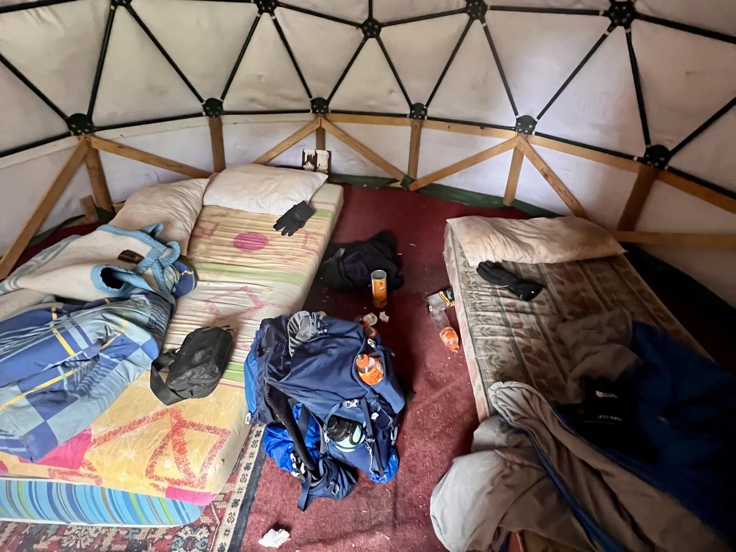 Inside the dome shelter at Italiano, with mattresses and hikers' packs on the floor