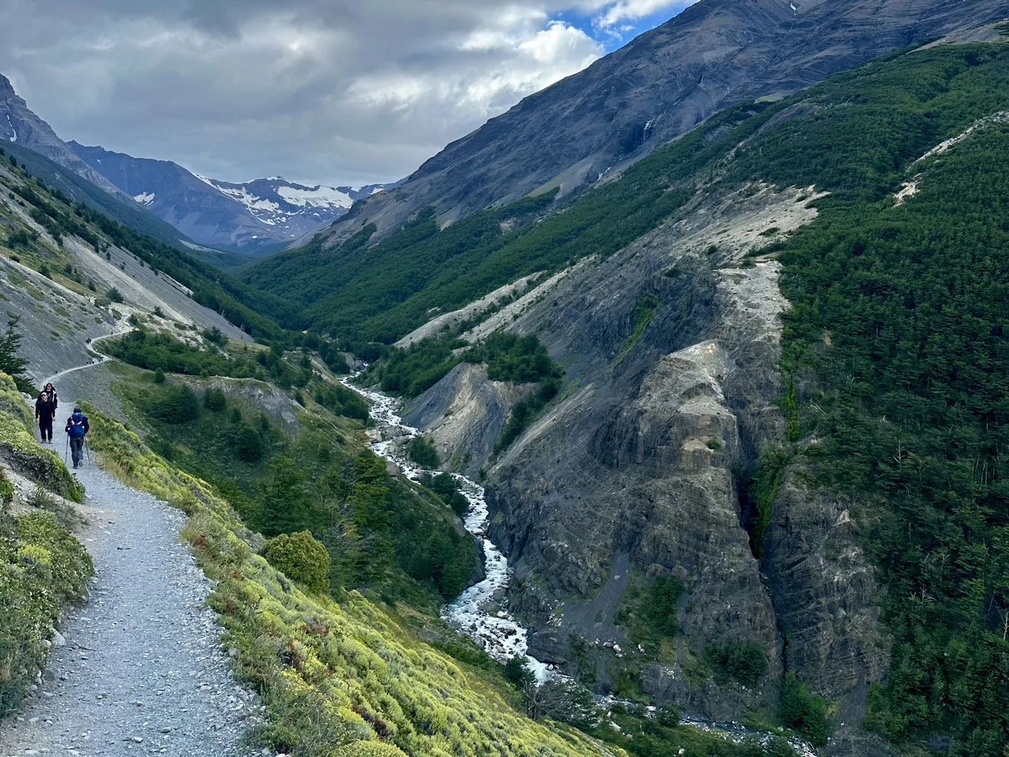 Hikers on the trail along the Ascencio Valley, with the river far below on the way to Chileno