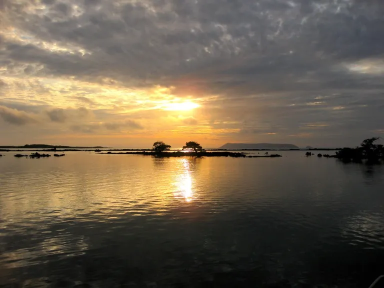 Sunrise over calm water from Concha de Perla, Puerto Villamil