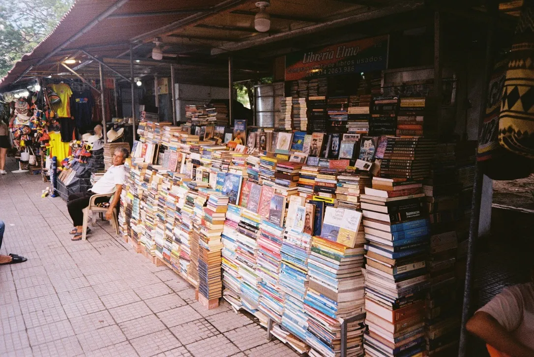 Secondhand book stall piled high at an outdoor market