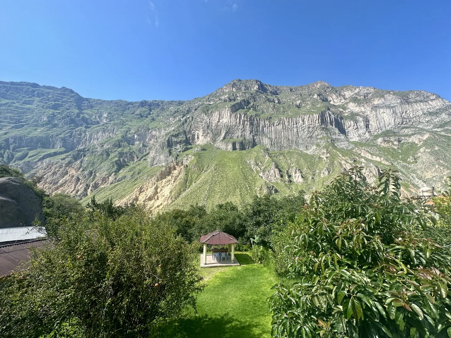 Garden and gazebo of a guesthouse in San Juan de Chuccho framed by the Colca Canyon walls