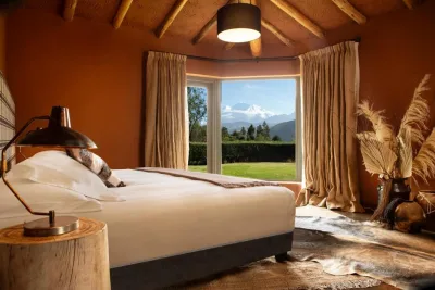 Bedroom at Cuesta Serena Boutique Hotel with a picture window framing a snow-capped peak over the garden