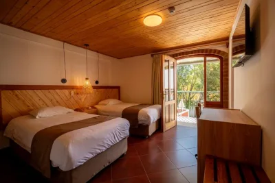Twin room at San Sebasti&aacute;n Hotel Boutique in Huaraz, with a wood-panelled ceiling and doors opening onto a balcony