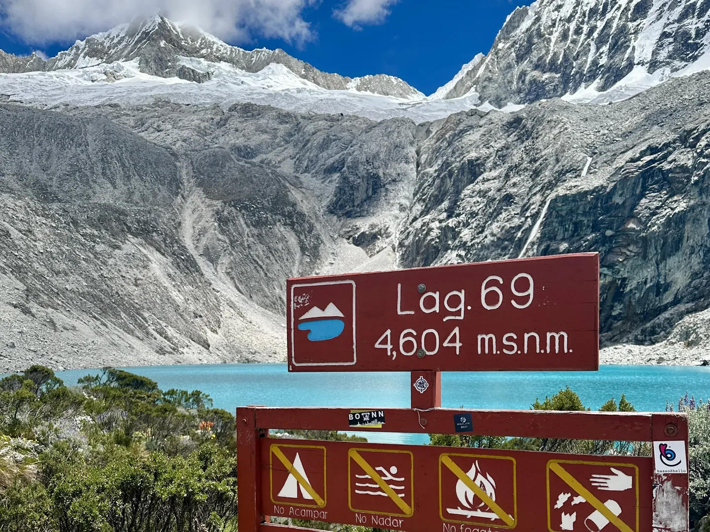 Trail sign at the top of the Laguna 69 climb marking 4,604 metres above sea level, with no swimming and no camping symbols