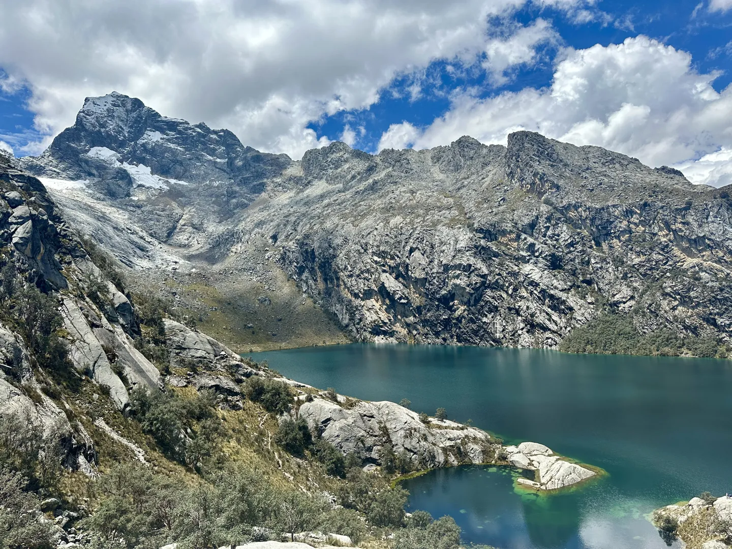 Laguna Churup from above, deep blue glacial water held between steep granite walls in the Cordillera Blanca