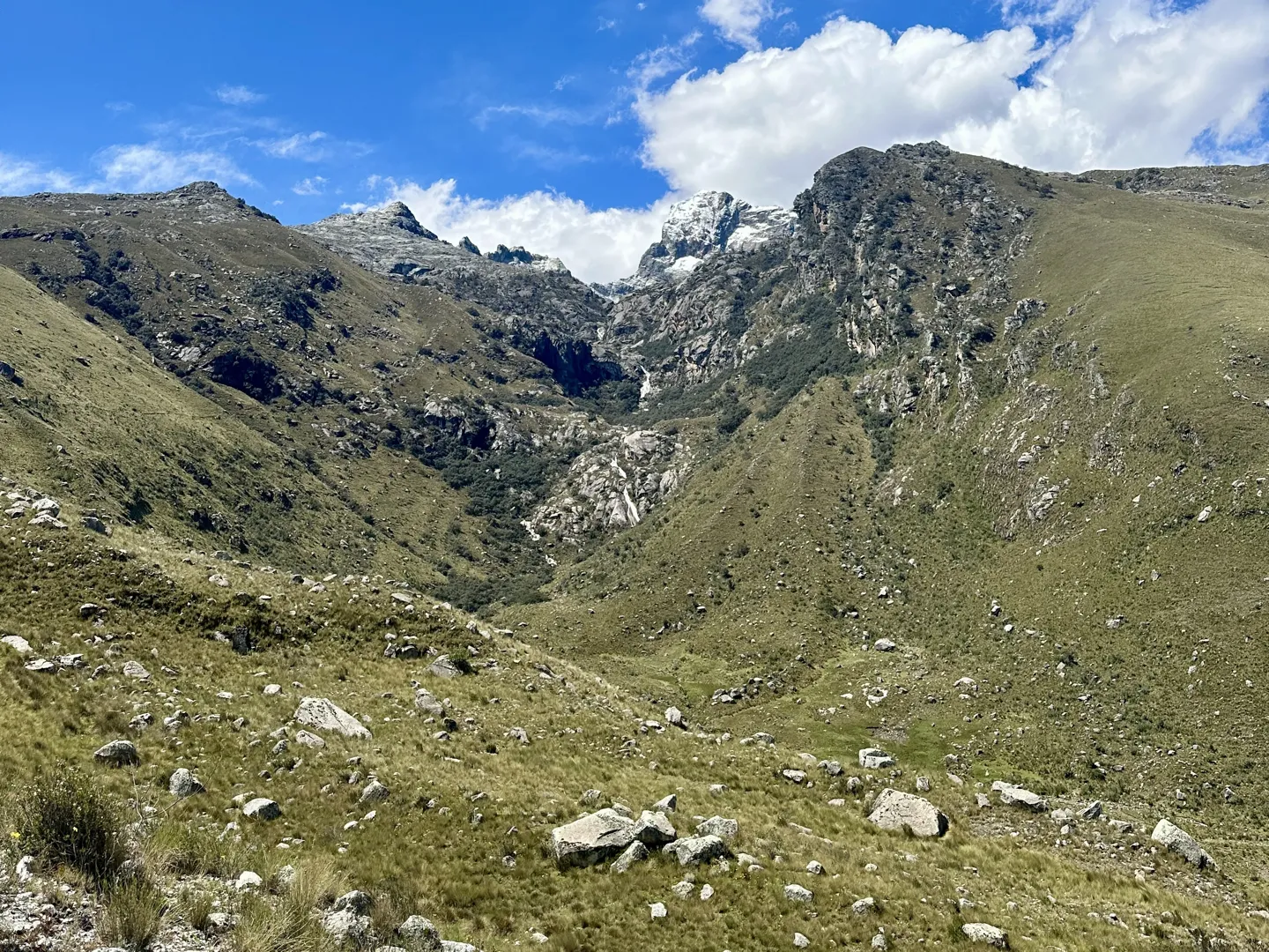 The wide grassy valley at the Pitec trailhead, a snow-capped Cordillera Blanca summit at the head of the gully