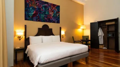 King room with colonial dark-wood headboard and local artwork at Novotel Cusco