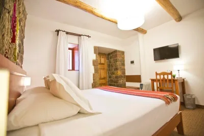 Double room with exposed Inca-stone wall and Andean runner at Tierra Viva Cusco Centro